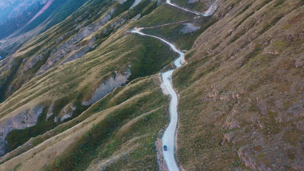 越野车在岩石山蜿蜒曲折的道路上行驶视频素材