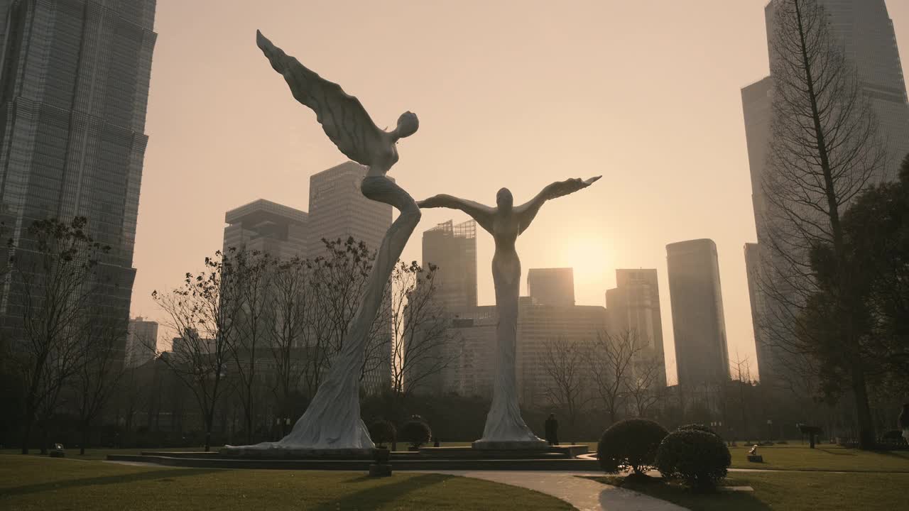 日落时分，上海陆家嘴中心绿地上的飞行双天使雕塑视频素材