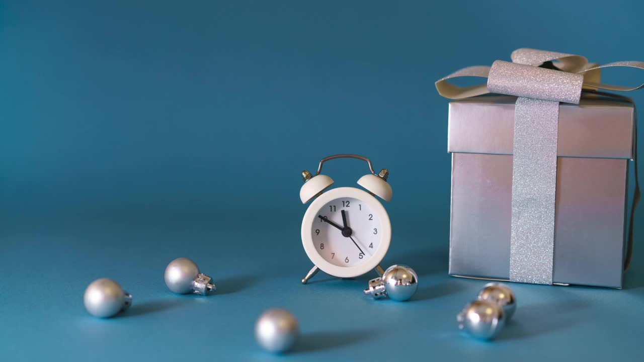 银色礼物与白色闹钟和圣诞装饰在蓝色视频下载