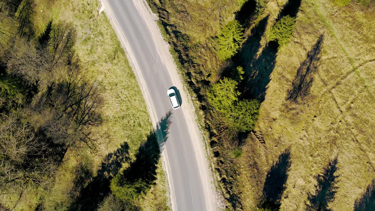 开车旅行。这条路通向山区。阳光明媚的一天，一架无人机飞过高速公路和绿色的圣诞树视频素材