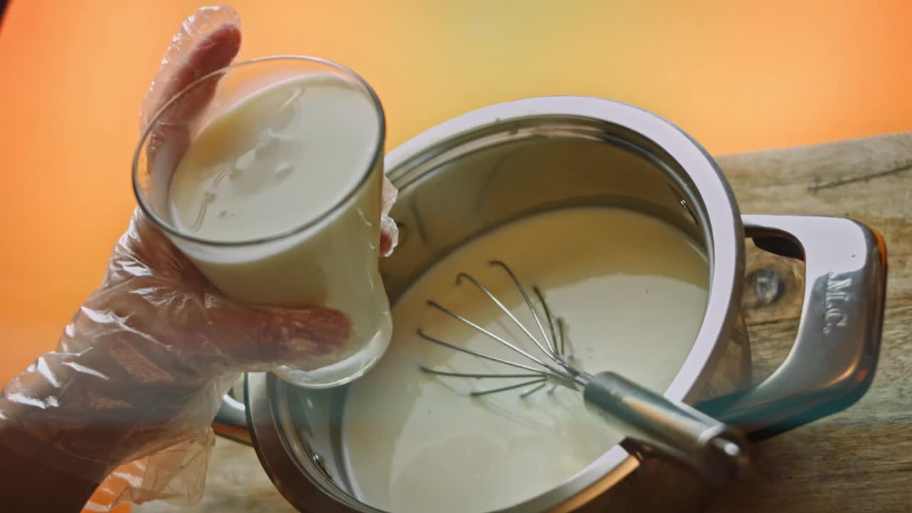 在冰淇淋配料上倒一杯牛奶，搅拌均匀。4 k的视频视频下载