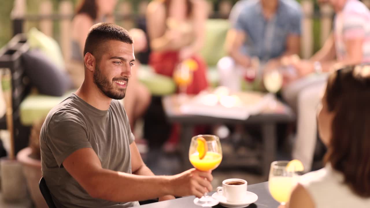 一个年轻人和他的女性朋友在咖啡馆敬酒。视频下载