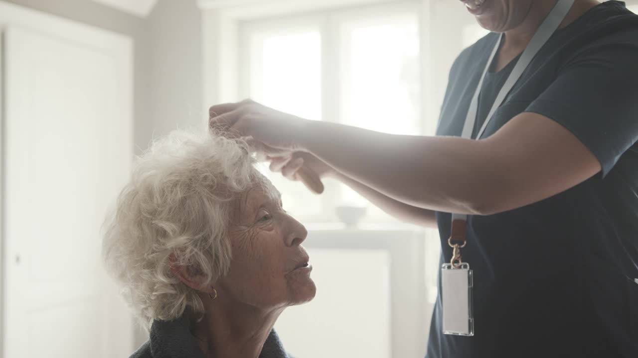 女护士梳理老年妇女的头发视频下载