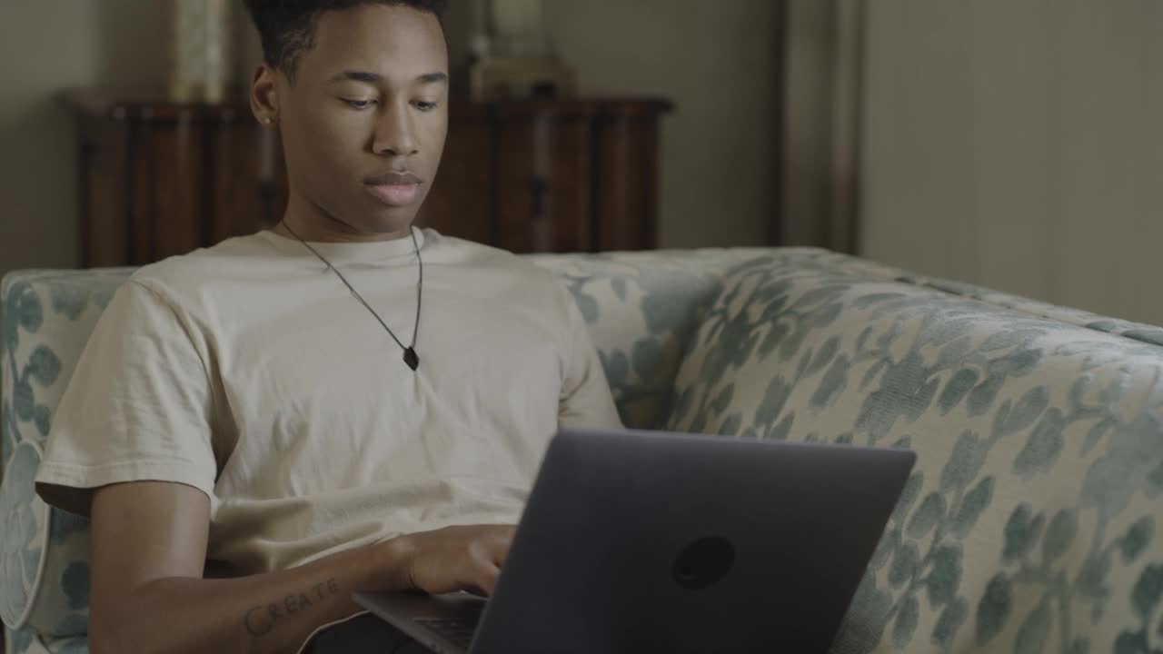 男子坐在沙发上使用笔记本电脑/ Cedar Hills，美国犹他州视频素材
