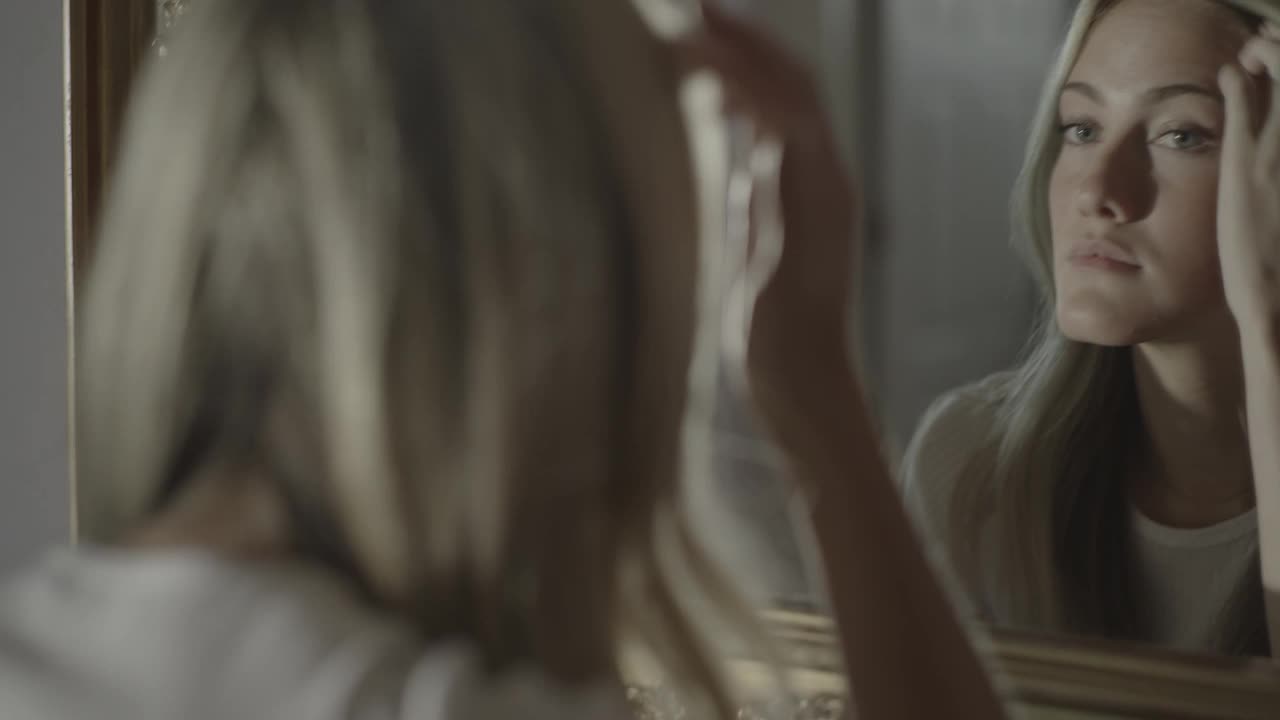 美国犹他州锡达希尔山，妇女在镜子里检查头发的近距离照片视频下载