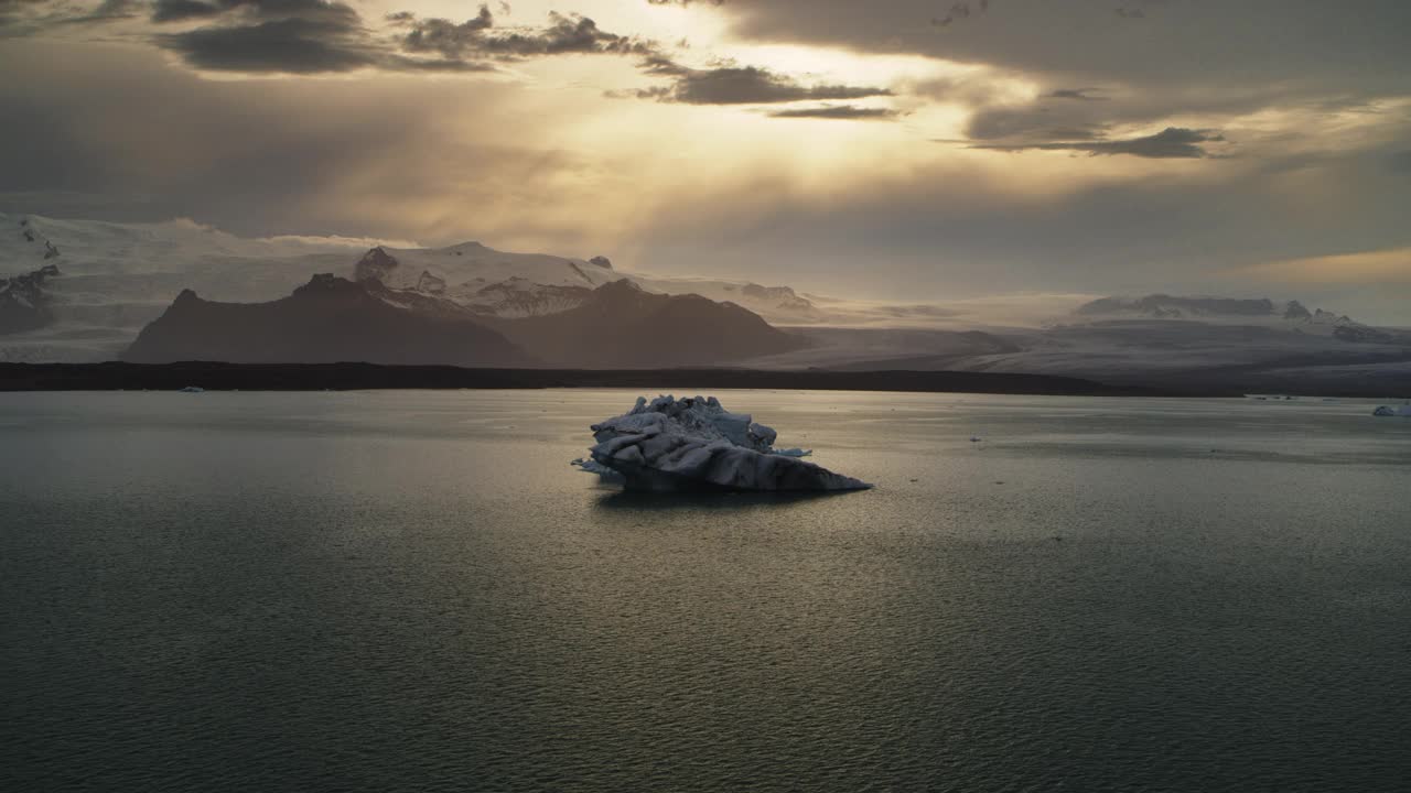 从空中俯瞰正在靠近的冰山在日落/冰岛的Jokulsarlon泻湖视频下载
