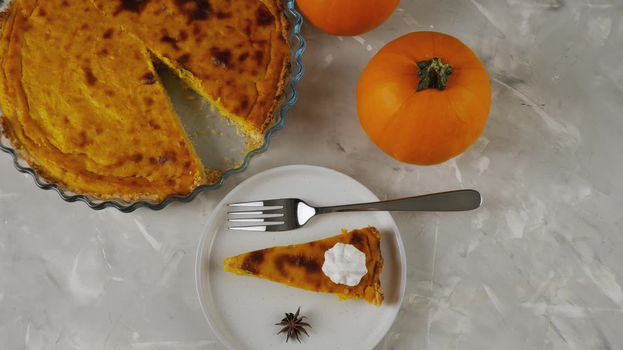 传统的美国甜点南瓜秋天派。新鲜出炉的南瓜派放在灰色的背景上。南瓜和馅饼视频下载