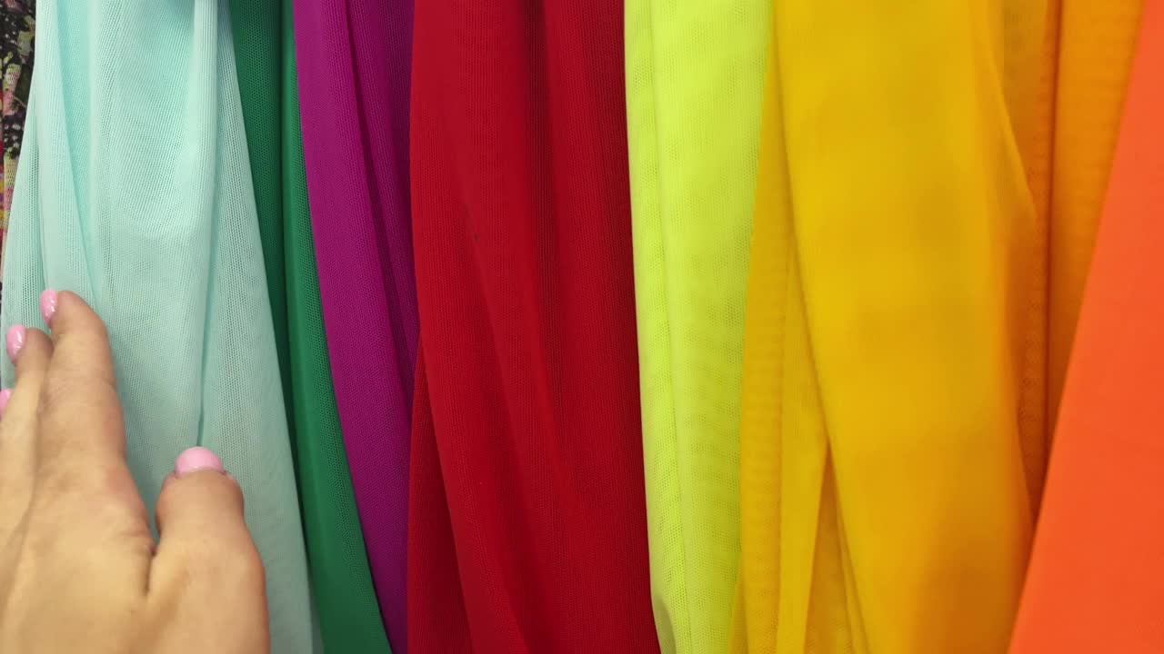 在一家纺织店买了4000多色的布料。女性的手触摸面料。视频下载