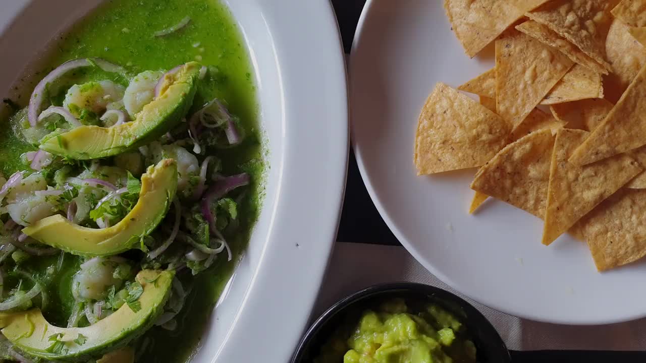 墨西哥食物俯视图镜头玉米片鳄梨酱和虾虾酸橙鳄梨沙拉4k视频下载