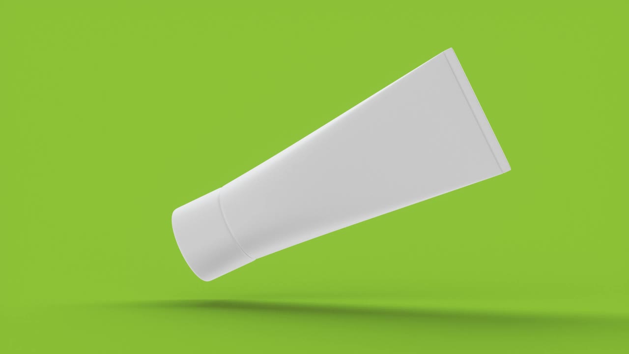特写白色模板空白包装管面霜在绿色背景。视频下载