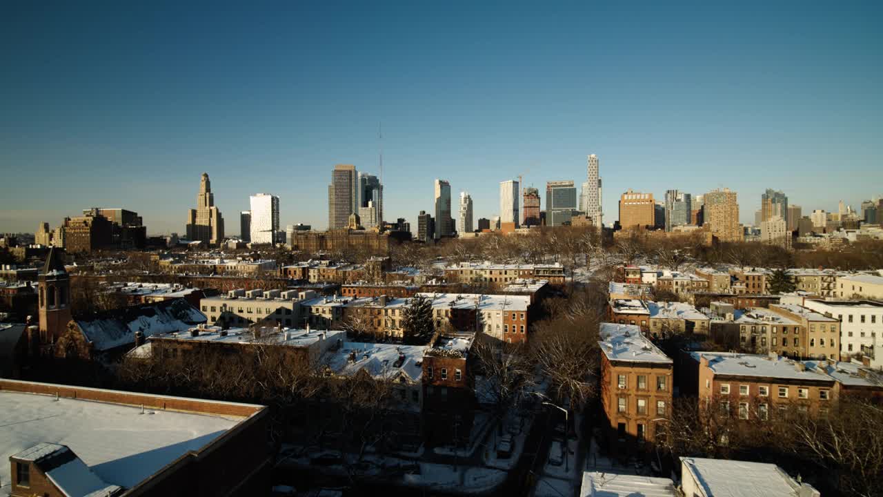 在冬天阳光明媚的清晨，从伯鲁姆山和格林堡公园的住宅区俯瞰布鲁克林市中心。无人机制作的视频，摄像机向前移动。视频下载