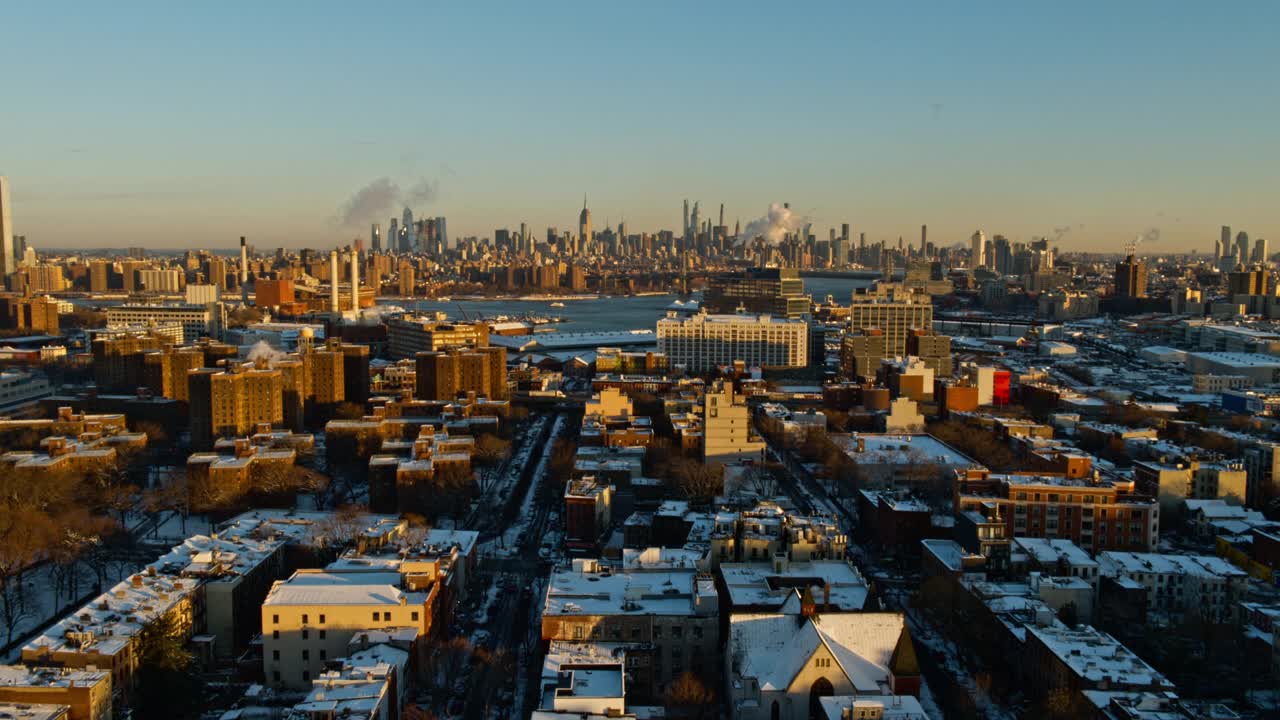 美国纽约市布鲁克林海军造船厂和威廉斯堡住宅区上空的曼哈顿，阳光明媚的冬日黎明。无人机视频与复杂的电影向后平移相机运动。视频下载