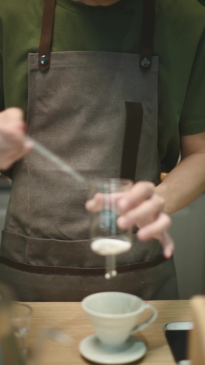 靠近亚洲华人男咖啡师加入咖啡过滤器准备冷萃冰滴咖啡在咖啡馆视频素材