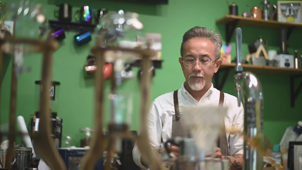 亚洲华人高级男咖啡师在咖啡店准备冰滴咖啡视频素材