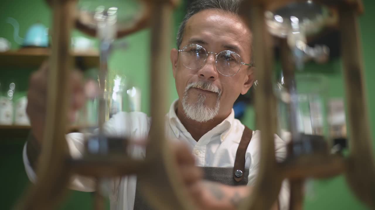 亚洲华人高级男咖啡师在咖啡店准备冰滴咖啡视频素材