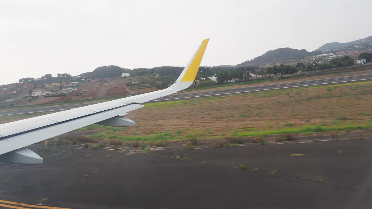 机场，从里面看到一架飞机降落并沿着跑道滑行。视频素材