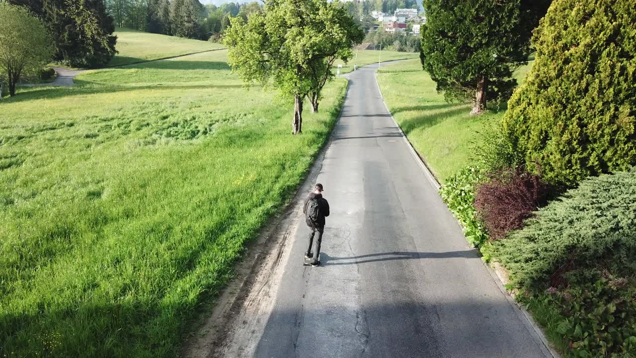 一名男子在瑞士乡村公路上玩滑板后，无人机坠毁。视频素材