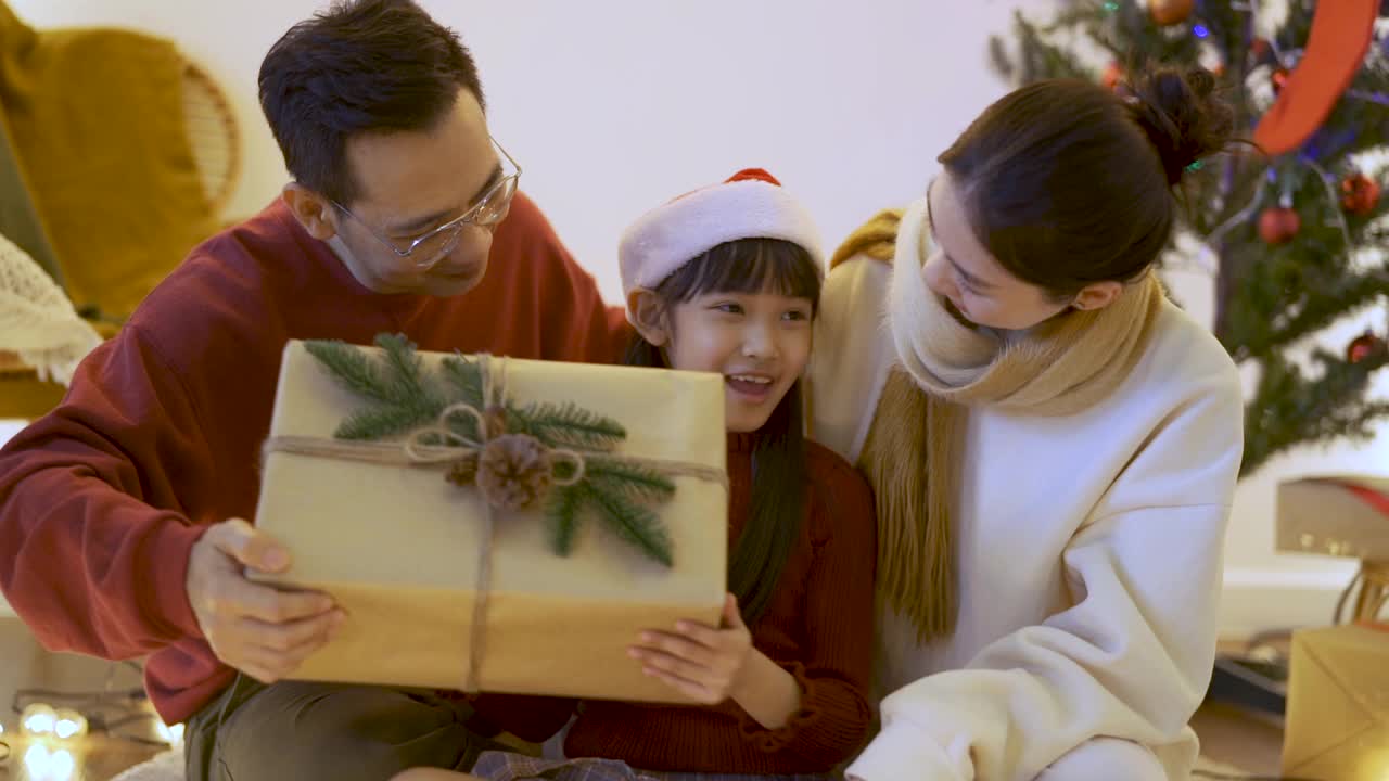 快乐女孩收到父母的圣诞礼物。视频素材