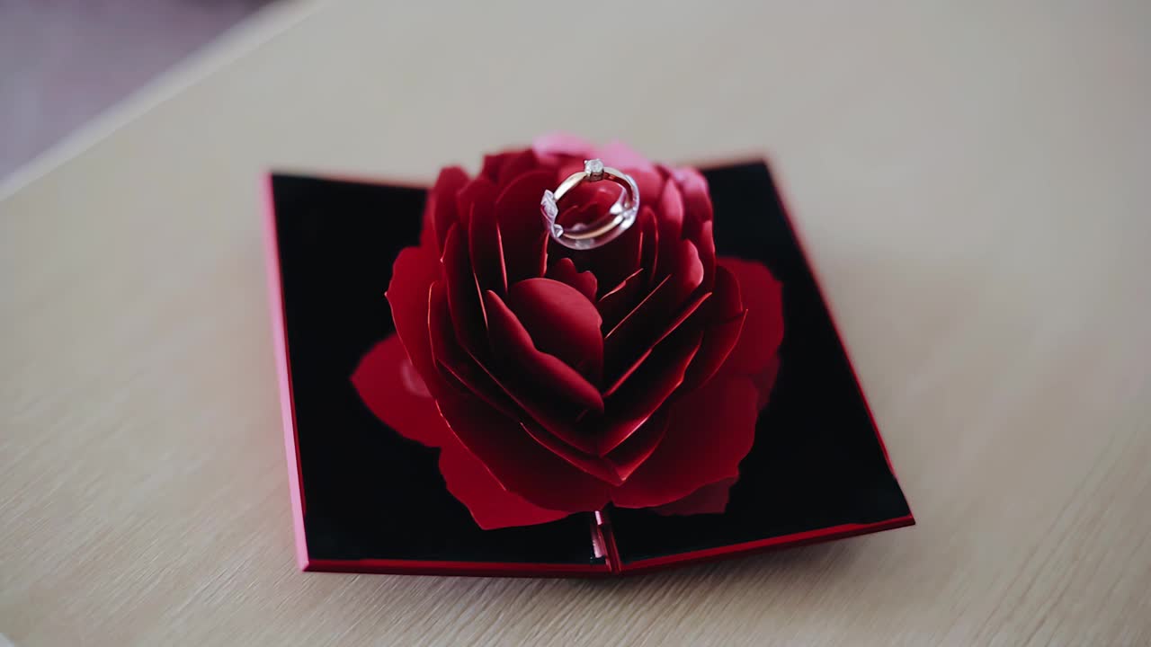一枚躺在玫瑰花蕾上的金戒指。动态特写拍摄视频素材