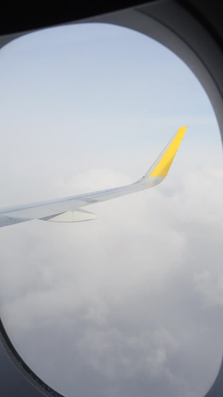 飞机在飞行，从飞机的窗户看白云和蓝天。视频素材