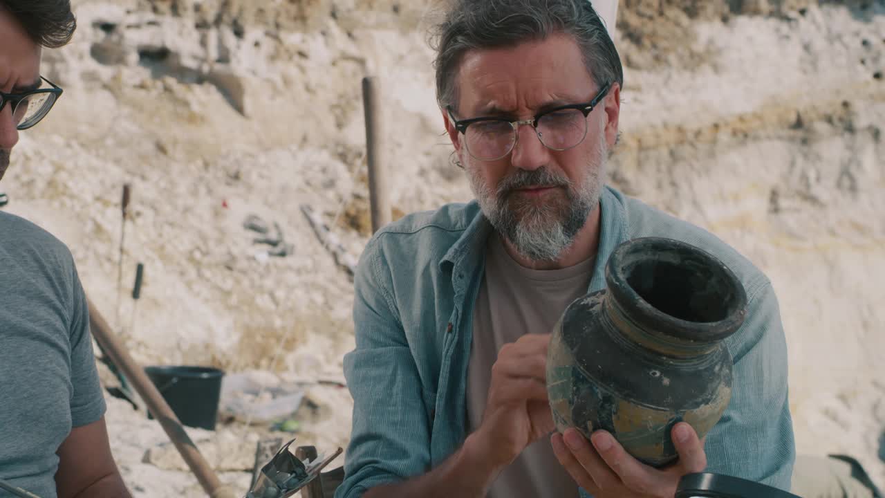 成熟的考古学家在清理附近的古董花瓶视频下载