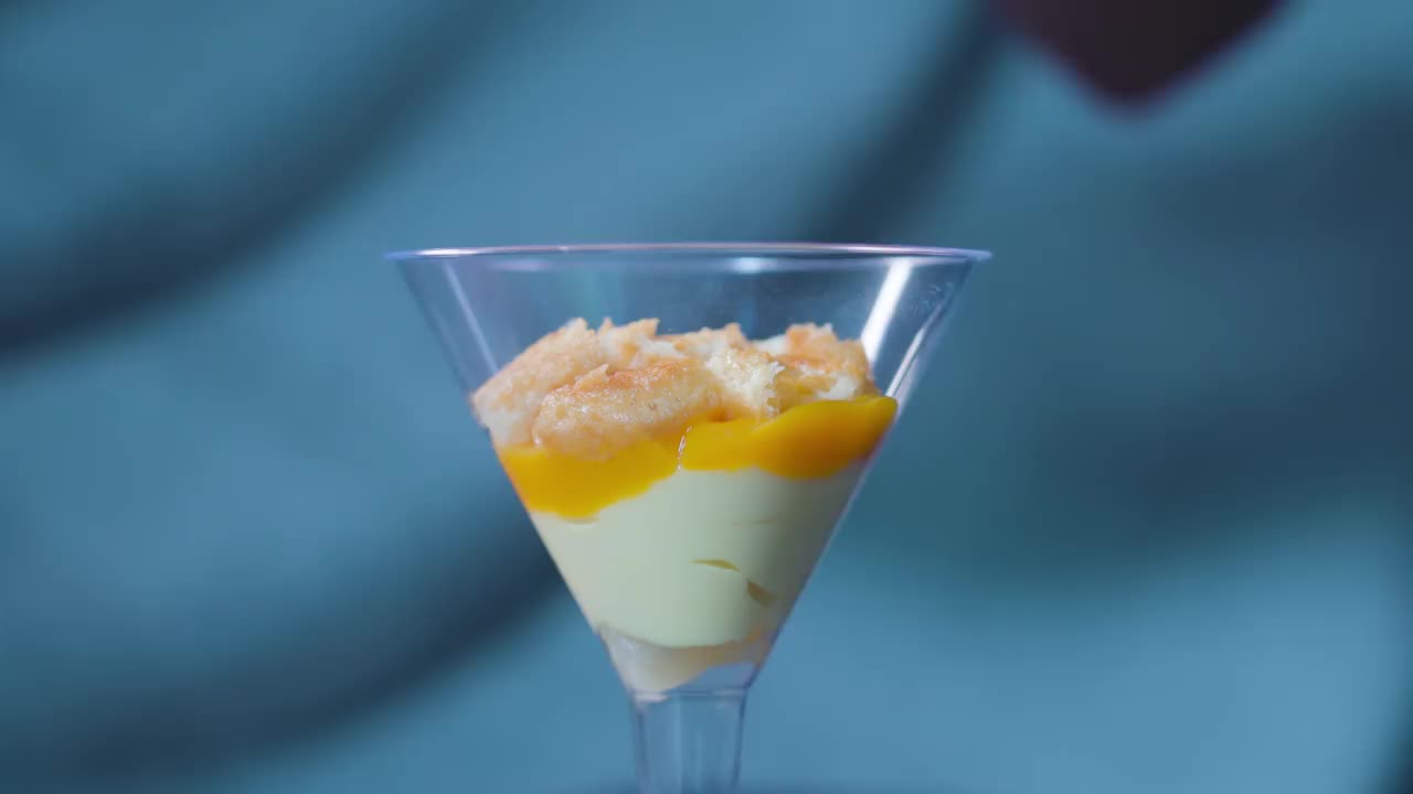 蛋奶沙司和芒果与手指饼干一起放入玻璃杯中视频素材