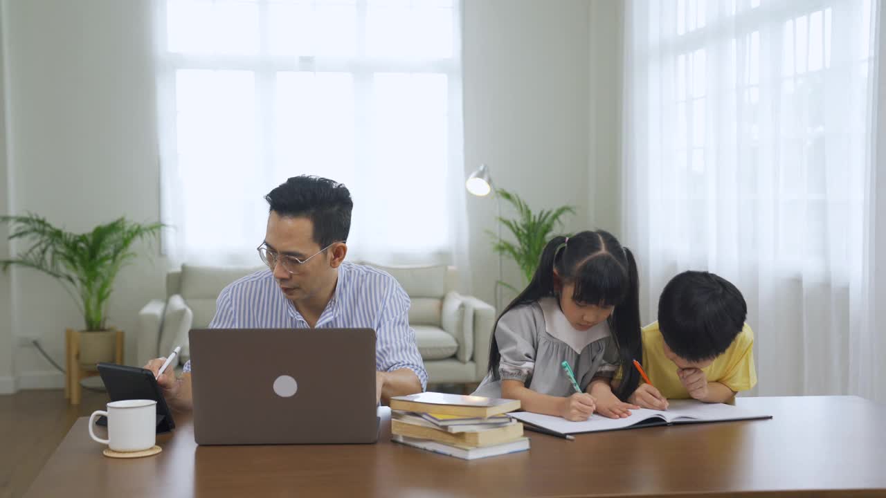 亚洲父亲在工作，孩子们在画画视频素材