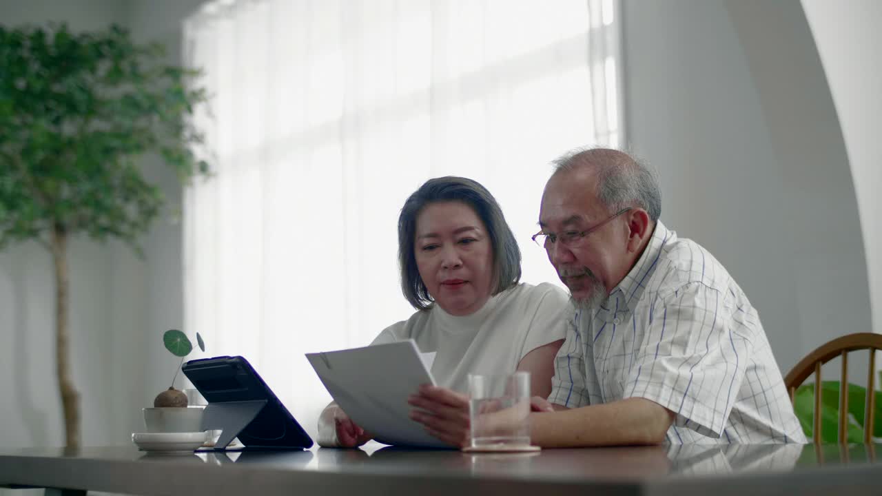 老夫妇在家里用笔记本电脑视频素材