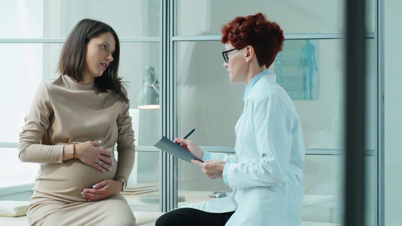 孕妇在诊所检查时与医生交谈视频素材