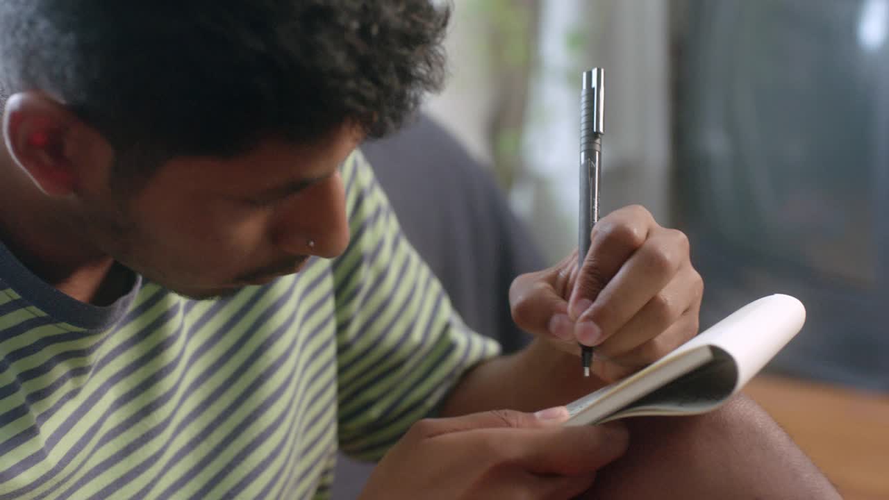 一个年轻的艺术家在他的笔记本上素描视频下载