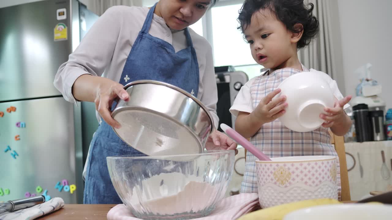 母亲和儿子一起做纸杯蛋糕。视频素材