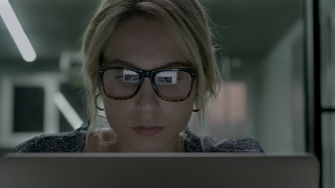 女人使用电脑时，电脑屏幕的光线会被眼镜反射视频素材