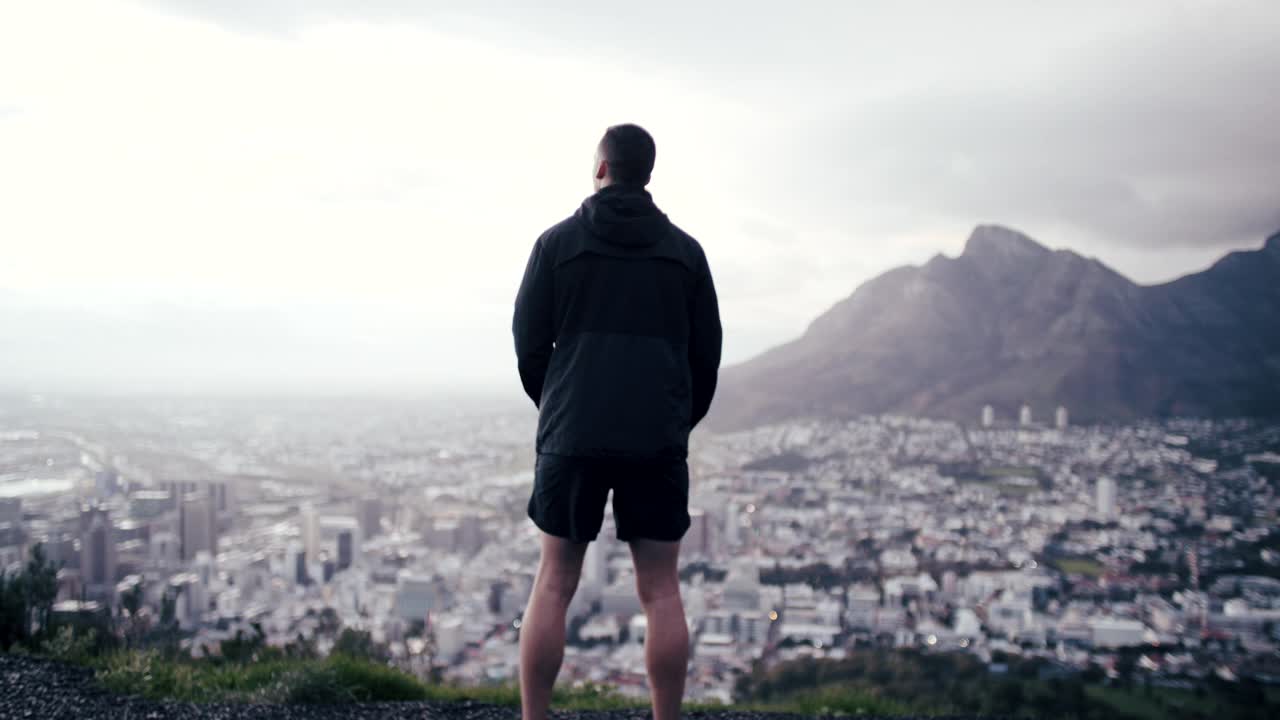 一段4k视频显示一名男子在跑步前休息，欣赏风景视频素材