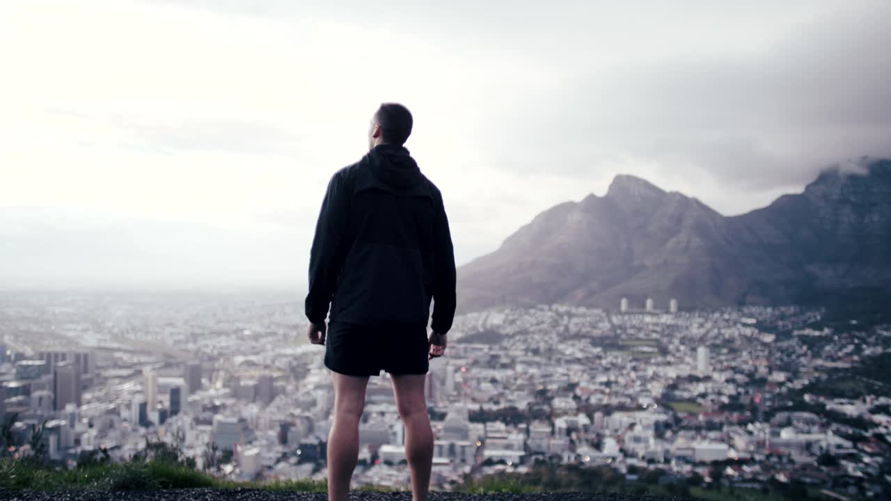 一段4k视频显示一名男子在跑步前休息，欣赏风景视频素材
