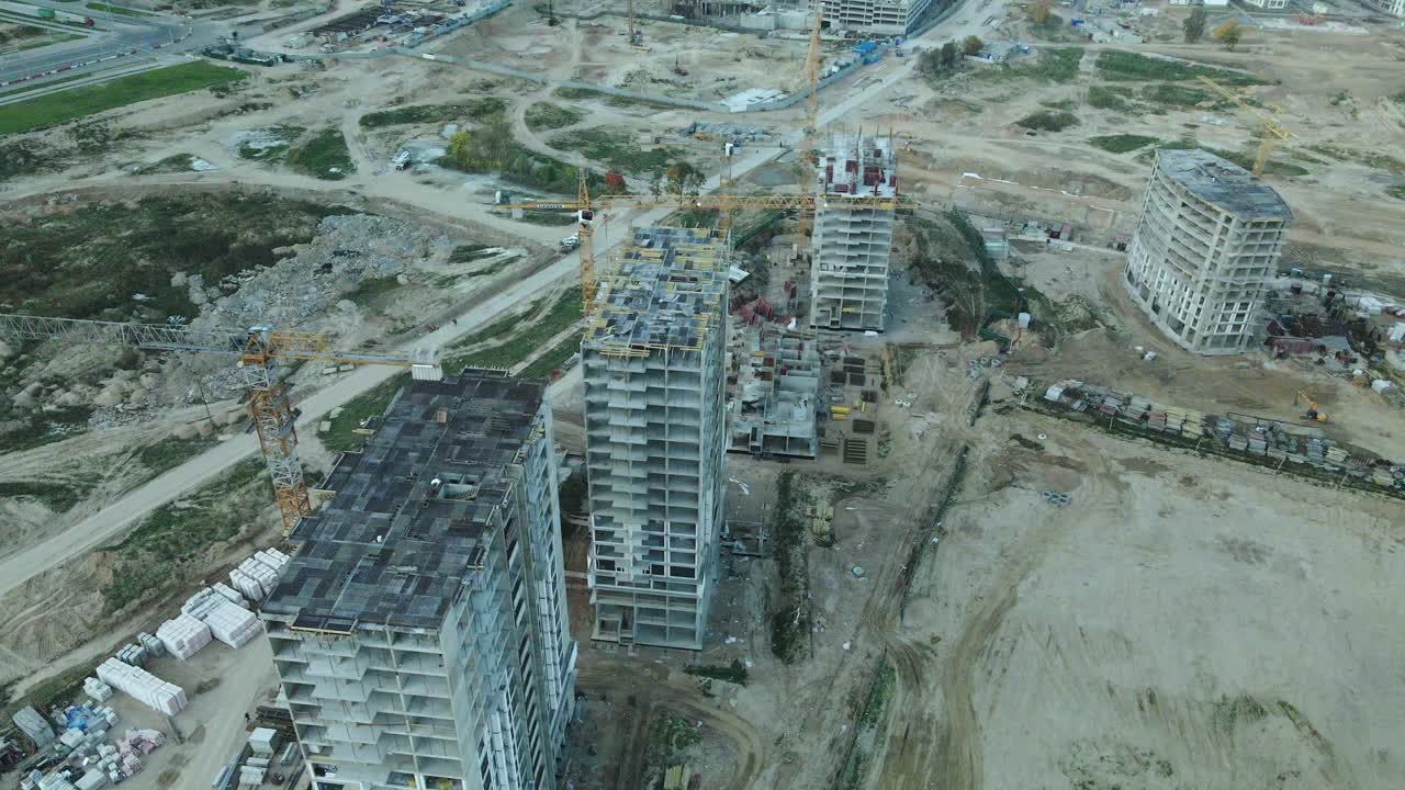 一个现代化城市街区的建筑工地。正在建设中的高层建筑。建筑塔式起重机。日落时的航空摄影。视频素材