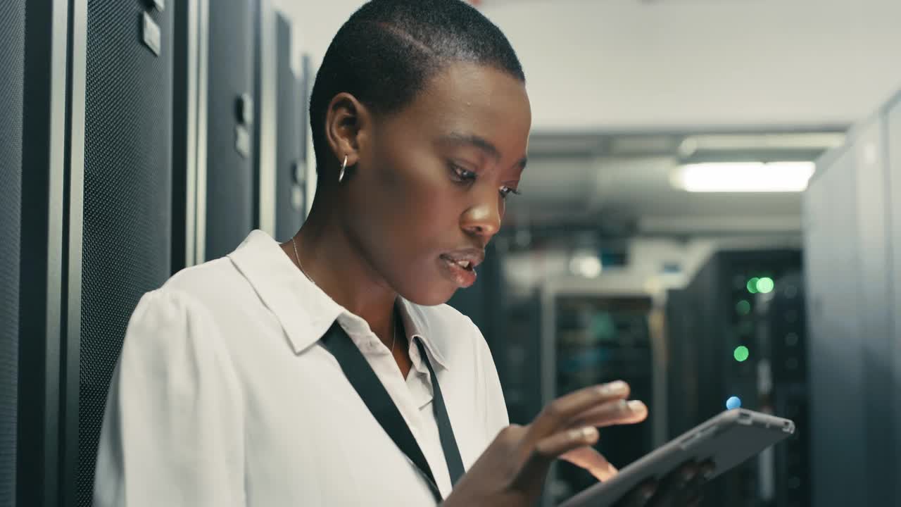 一名年轻技术人员在服务器室使用数码平板电脑进行维护检查的4k视频片段视频下载