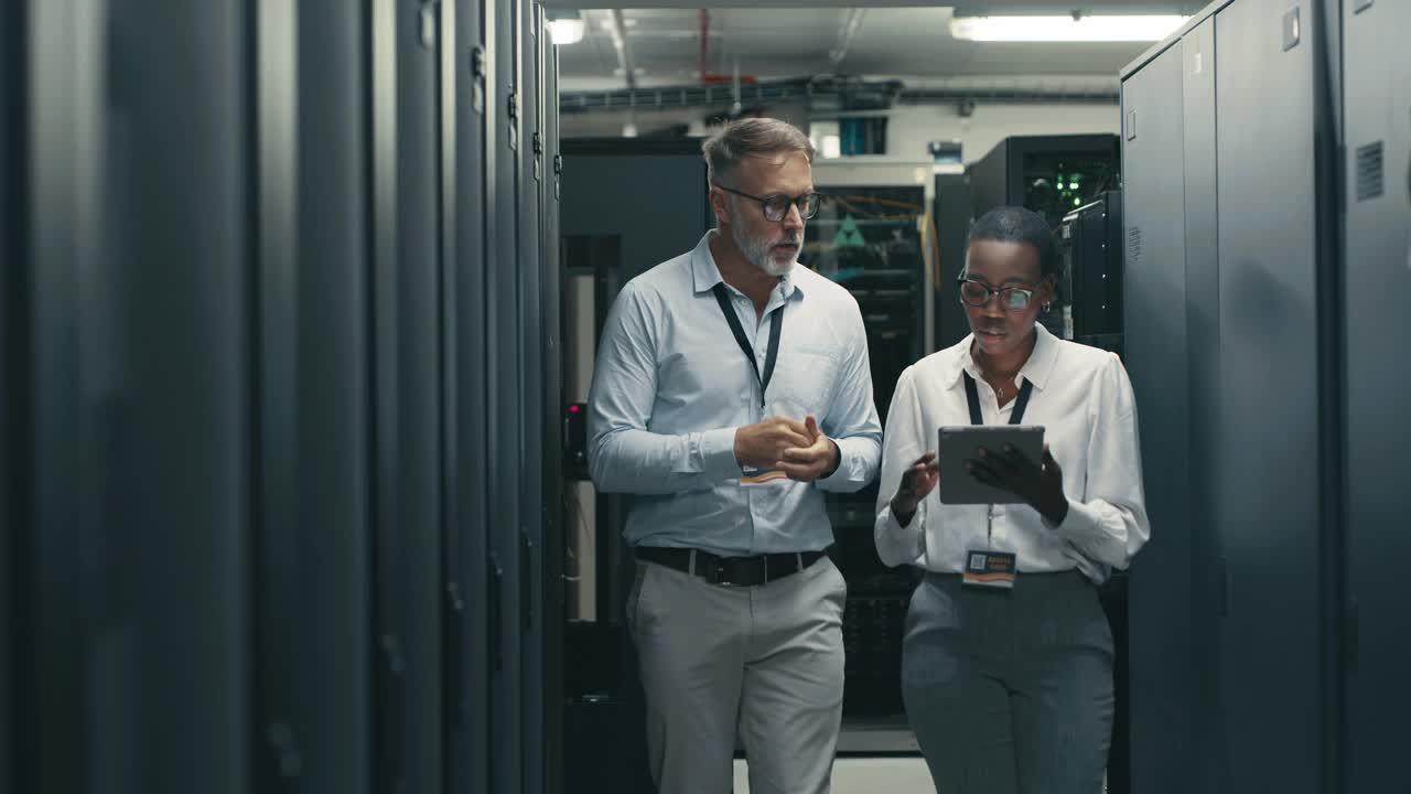 一段4k视频显示，两名技术人员一起站在服务器室里，用一台数字平板电脑进行讨论视频下载