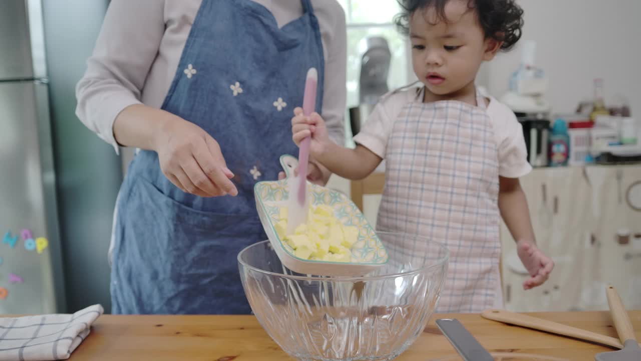 母亲和儿子一起做纸杯蛋糕。视频素材