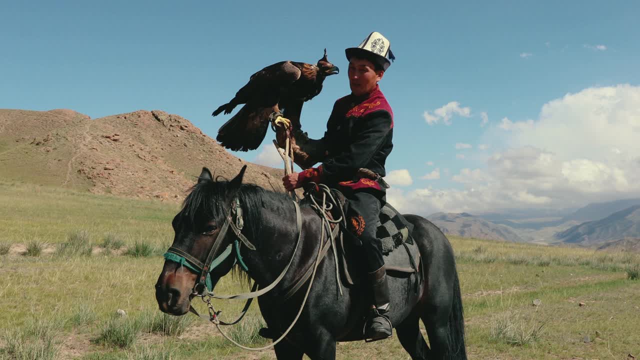 在吉尔吉斯斯坦的天山，骑在马上的鹰猎人视频下载