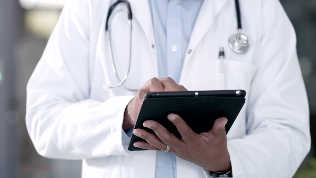 一个不知名的医生在工作时使用数字平板电脑的4k剪辑视频视频素材