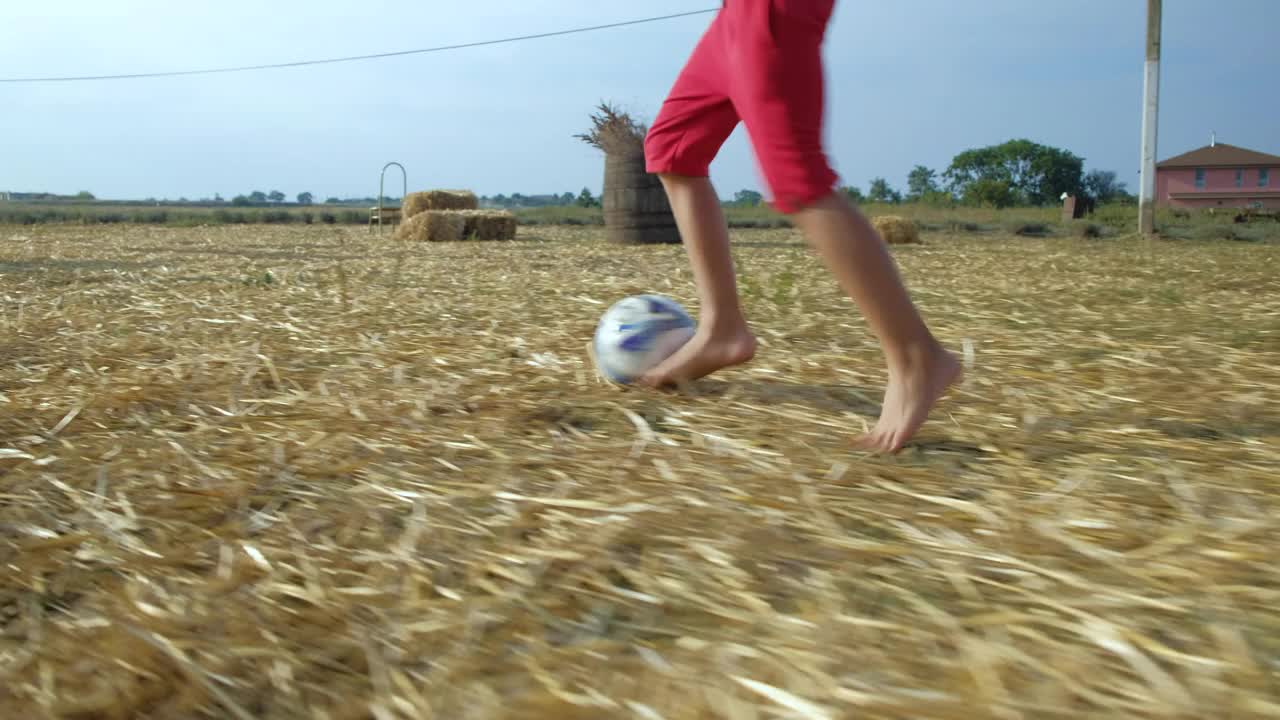一个少年拿着足球跑过场地视频下载