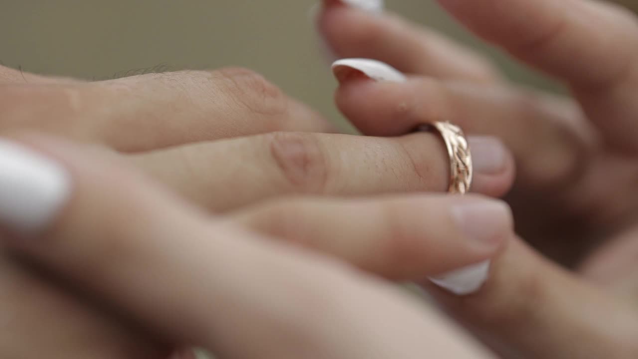 新娘戴上新郎的结婚戒指，特写镜头视频素材