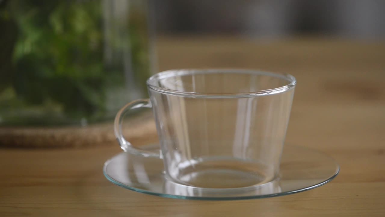 将热薄荷茶倒入透明玻璃茶杯中。视频素材