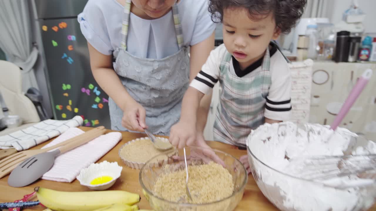 母亲和儿子一起做甜点视频素材