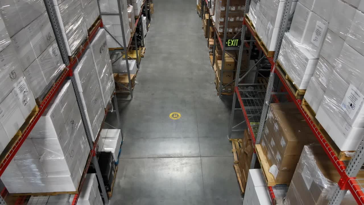 仓库工人用托盘千斤顶搬运货物托盘的高空高角度摄影视频素材
