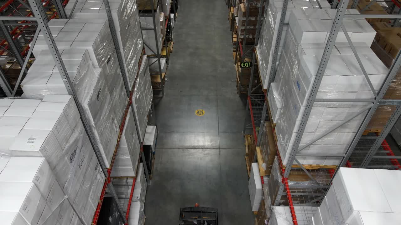 仓库工人用叉车搬运货物托盘的高空高角度台架拍摄视频素材