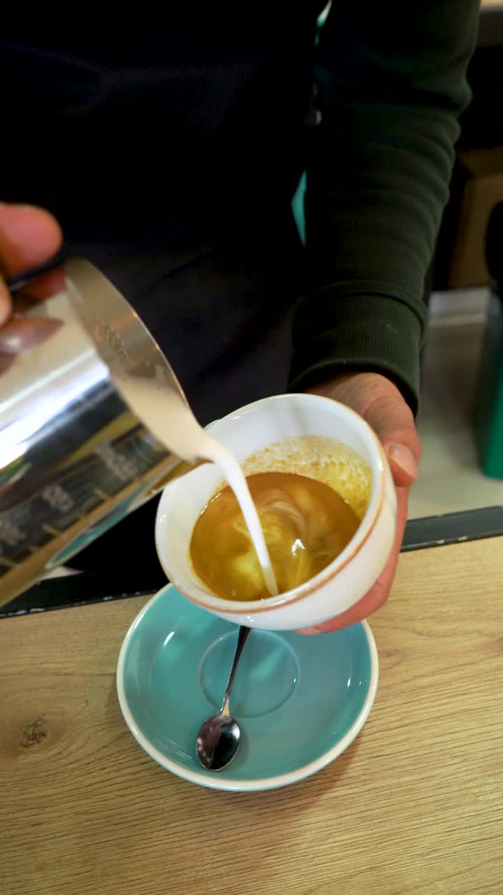 拉丁男子咖啡店员工设计咖啡杯上的花视频素材