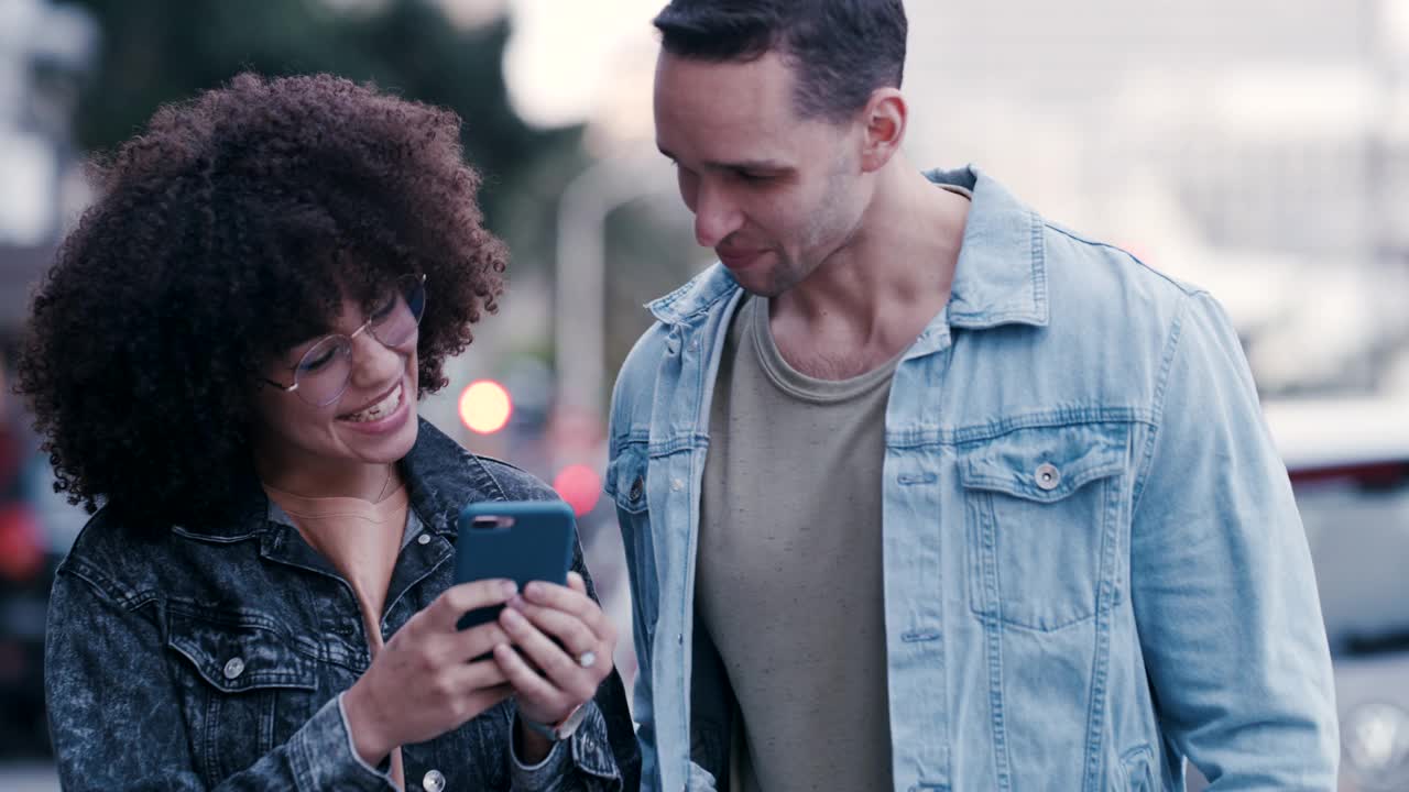 一对年轻夫妇在城市里用手机看东西的4k视频视频素材