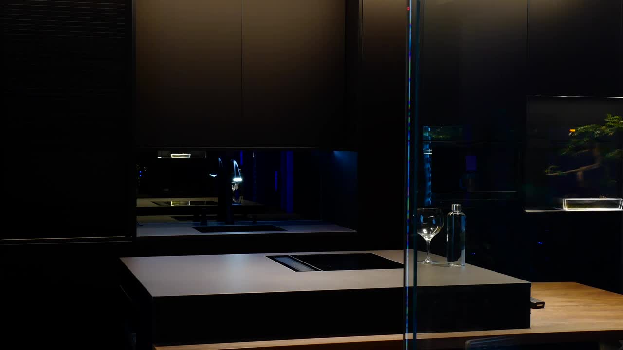 玻璃门打开在一个照明美丽和现代厨房与反射在夜间视频下载