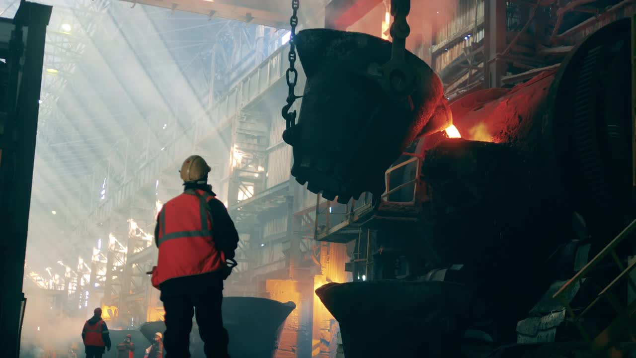 钢铁厂工人正注视着装着熔化的金属的钢包视频素材